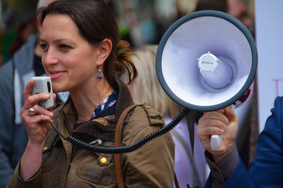 Una mujer sosteniendo usando un megáfono