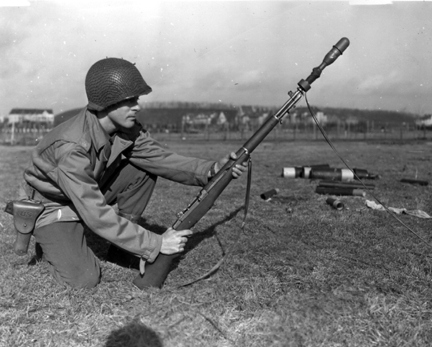 A military person holding a weapon in a black and white photo