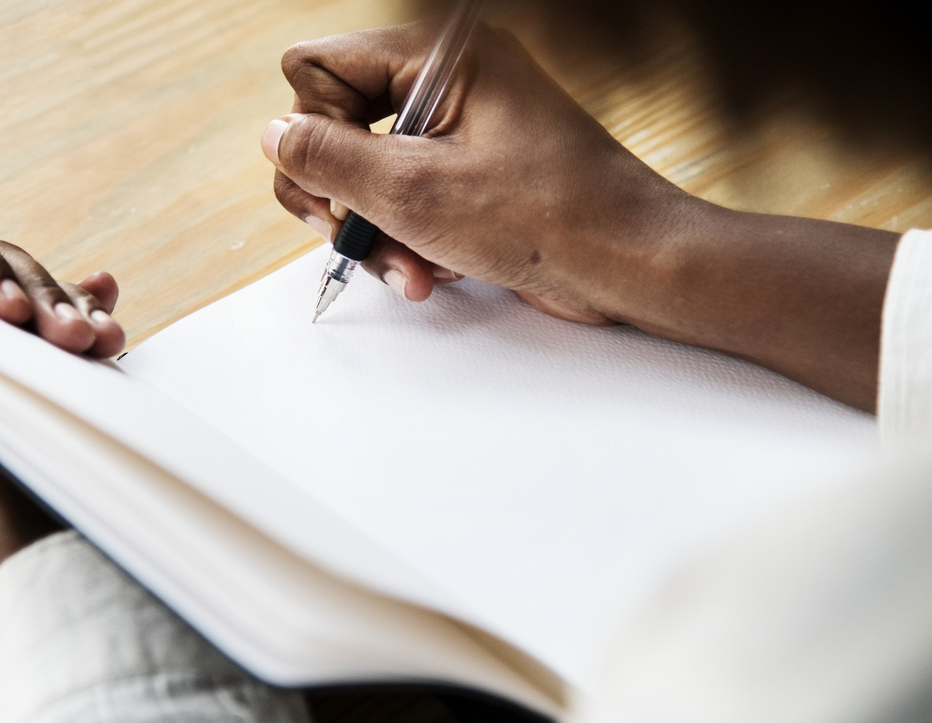 A woman preparing to write in a notebook