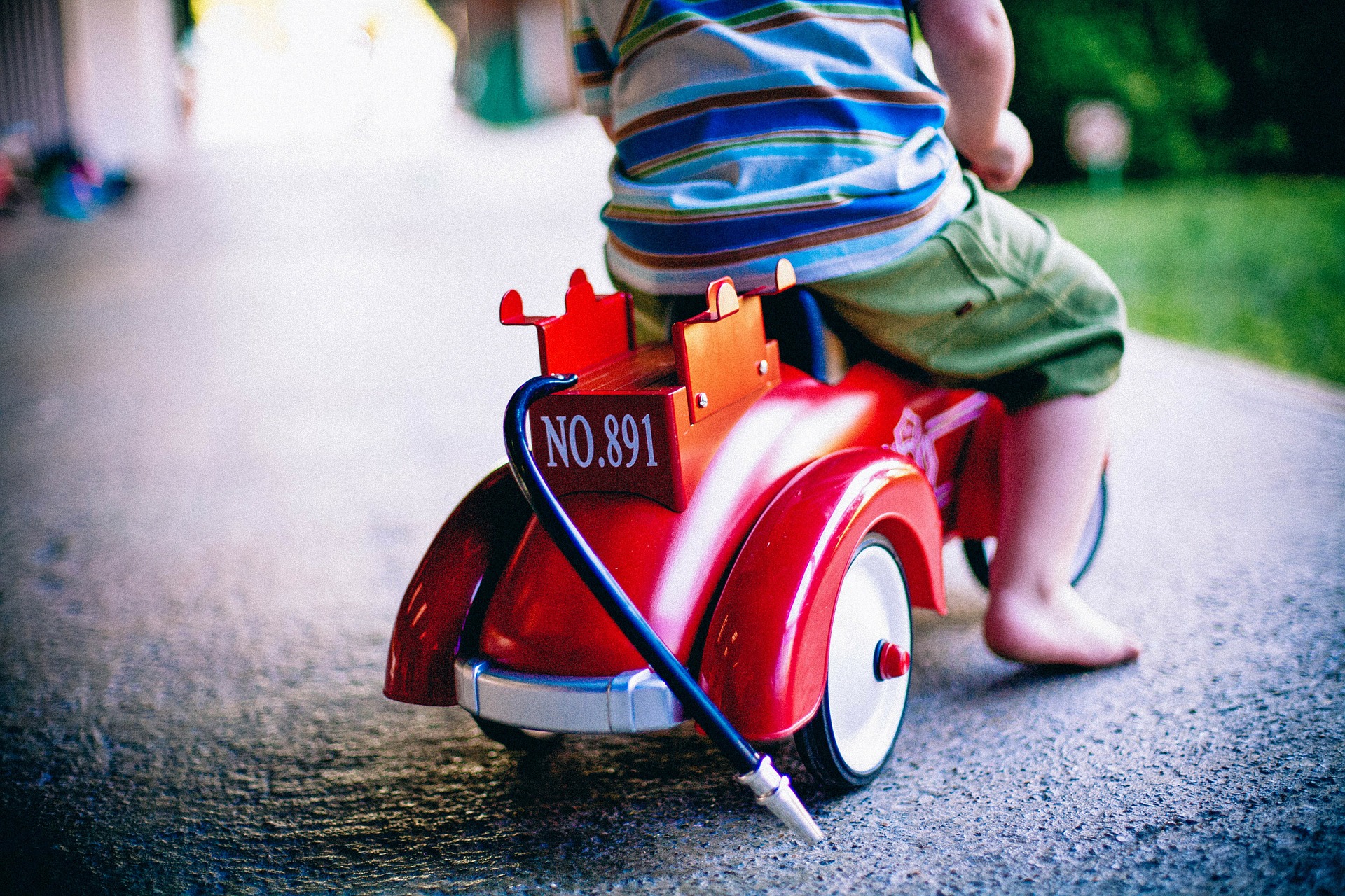 niño montando un coche de juguete