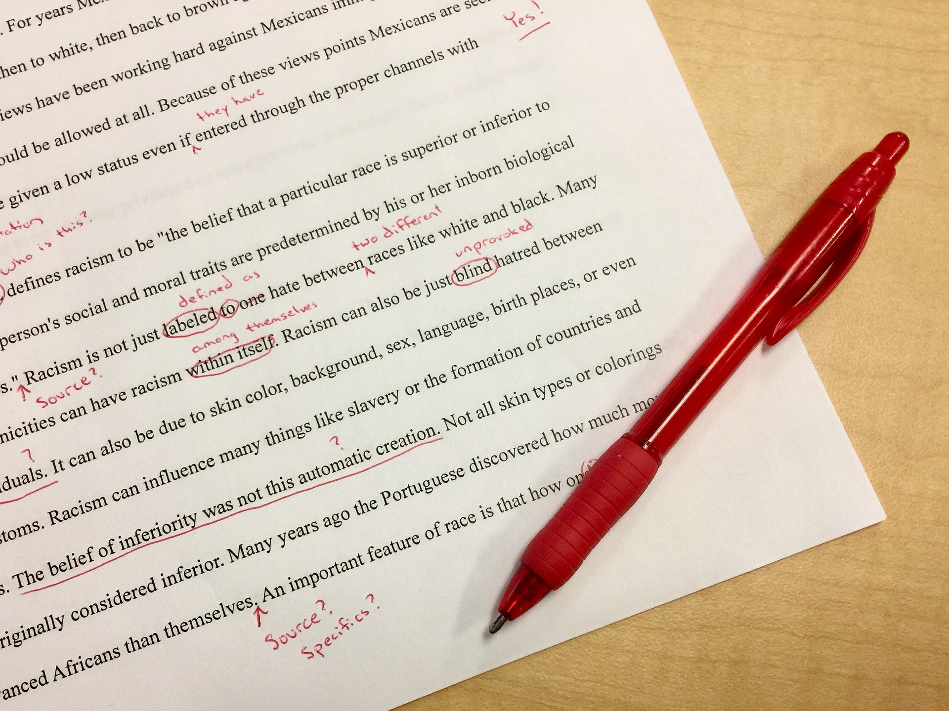 A paper with red annotations and a red pen laying on top