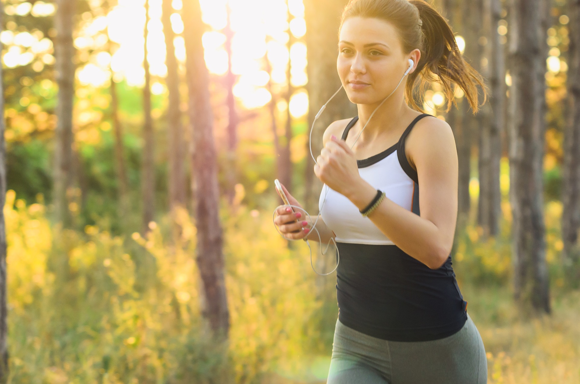 Una mujer haciendo footing con los auriculares puestos