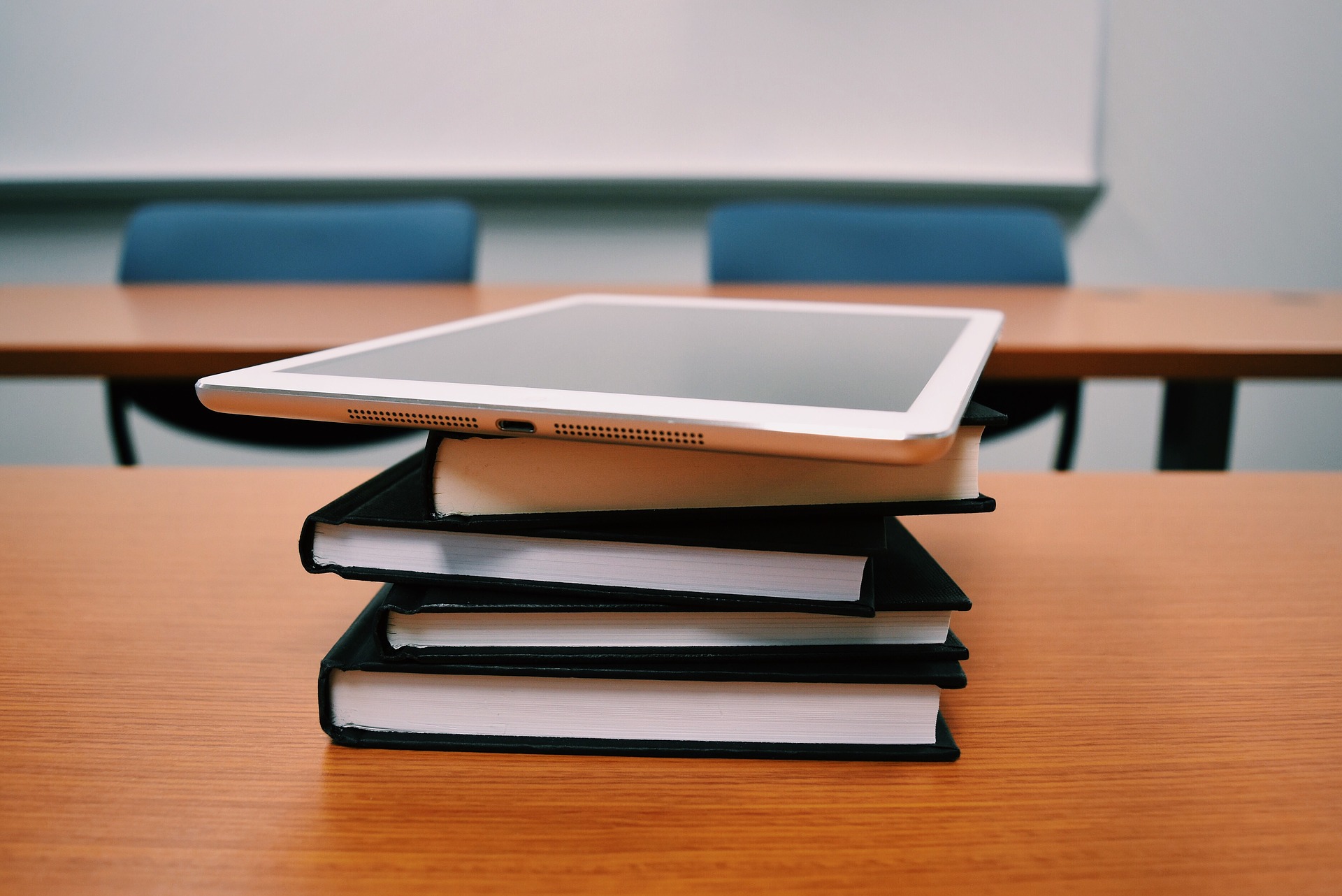 Stacked books with a tablet on top