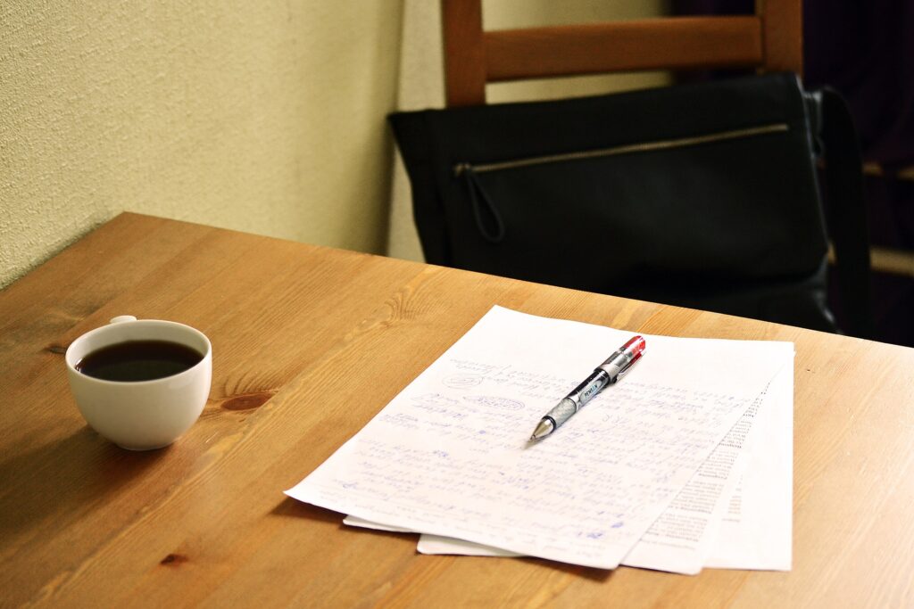 A page of handwritten writing sitting on top of paper with printed text