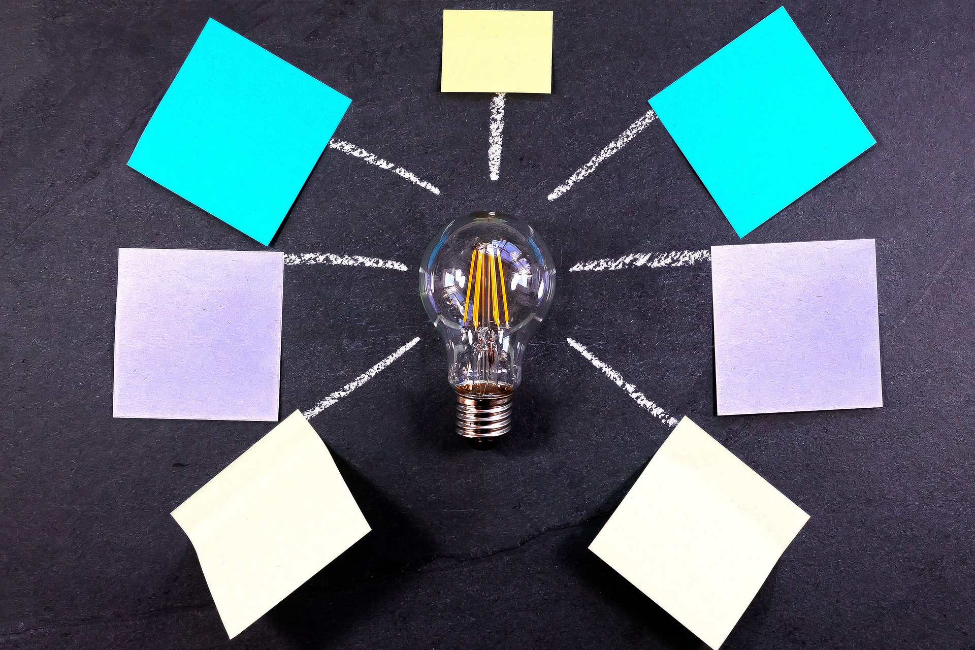 Light bulb surrounded with post-it notes