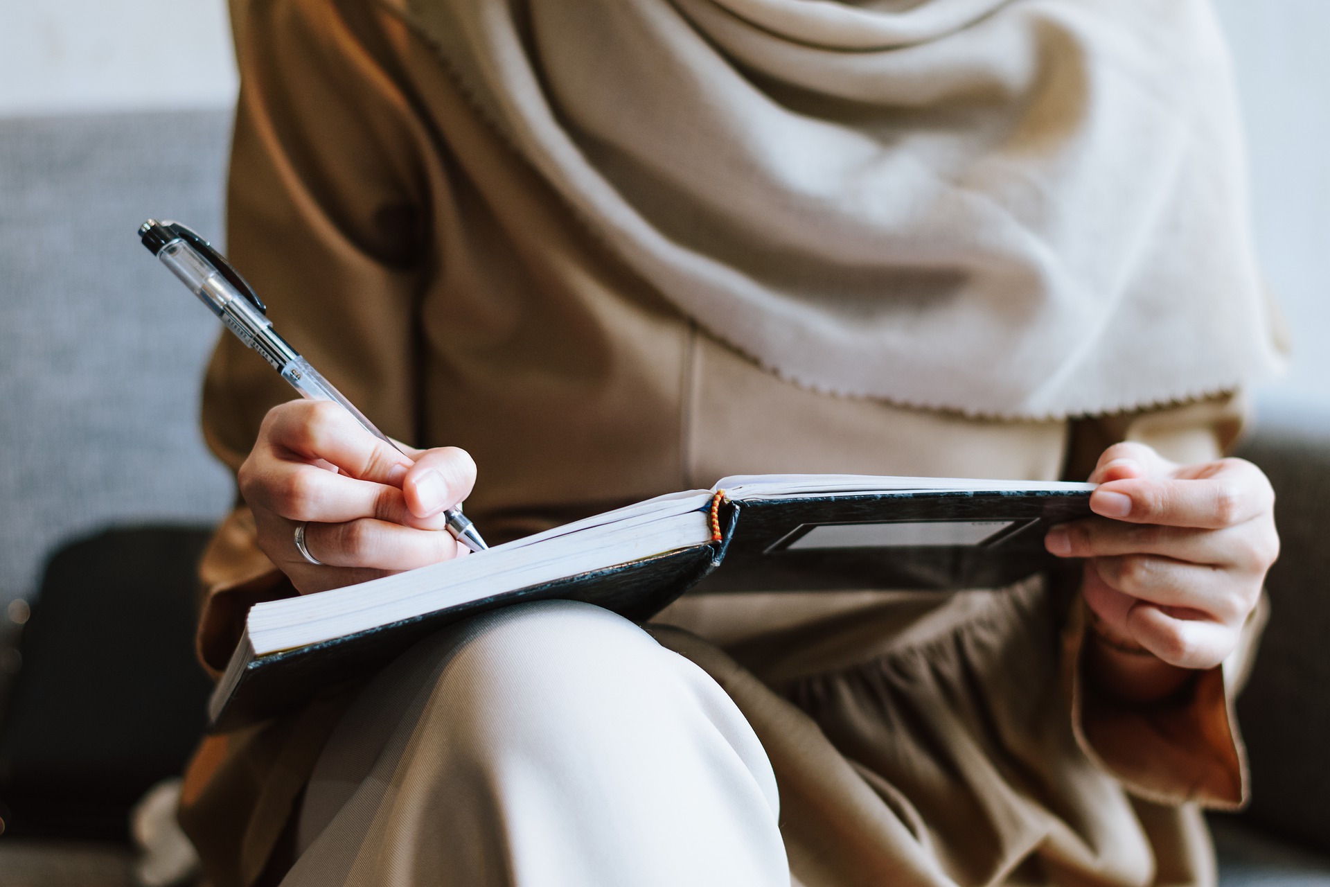 Una mujer escribiendo en un cuaderno.